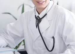 聴診器を首にかけた白衣の医師の写真